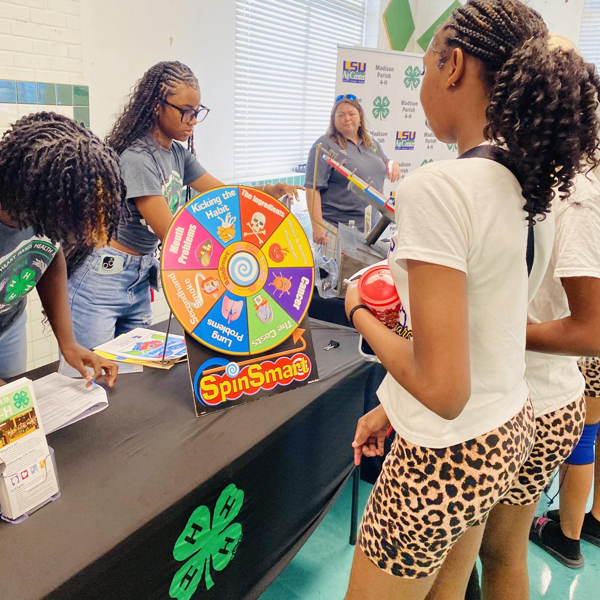 A girl looking at a spin the wheel game on a table.